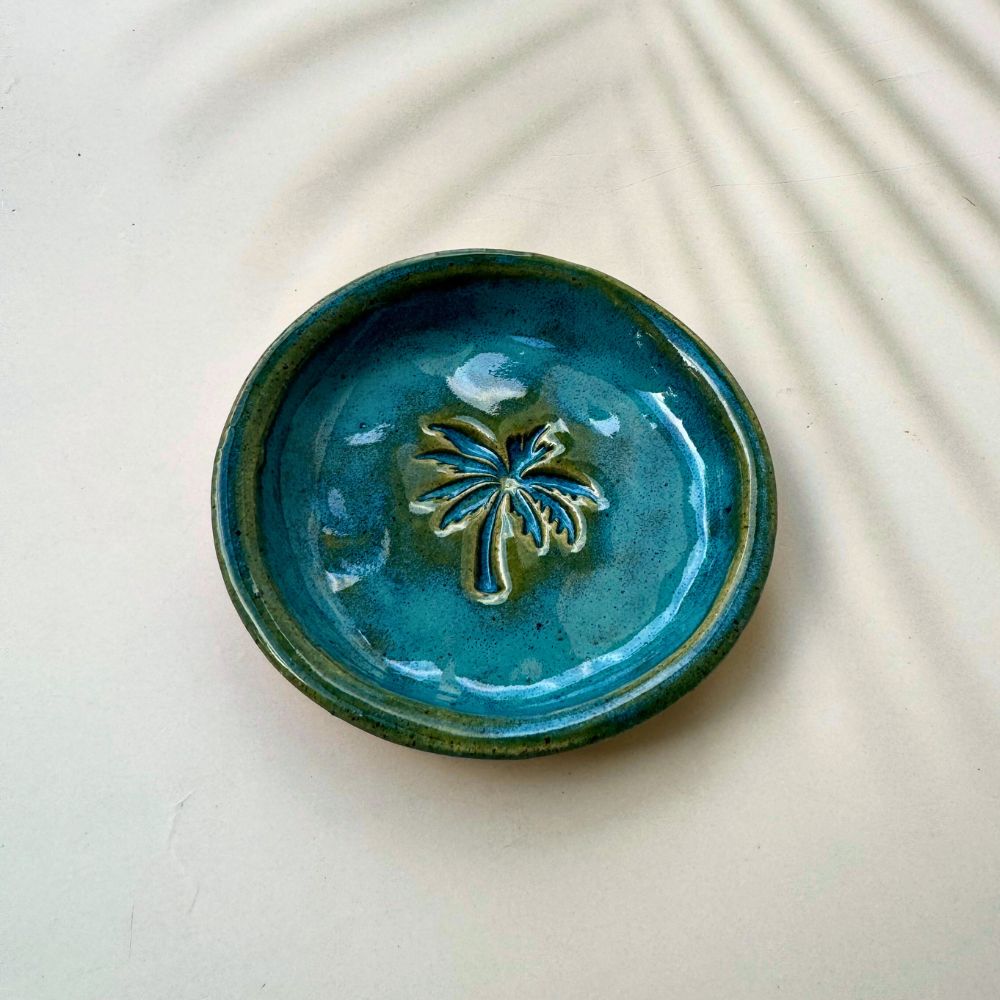 Blue ceramic dish with a leaf design on a light background